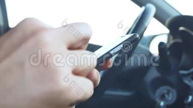 男人在车里拿着智能手机。 男人在智能手机上获得短信在线社交媒体生活方式交流